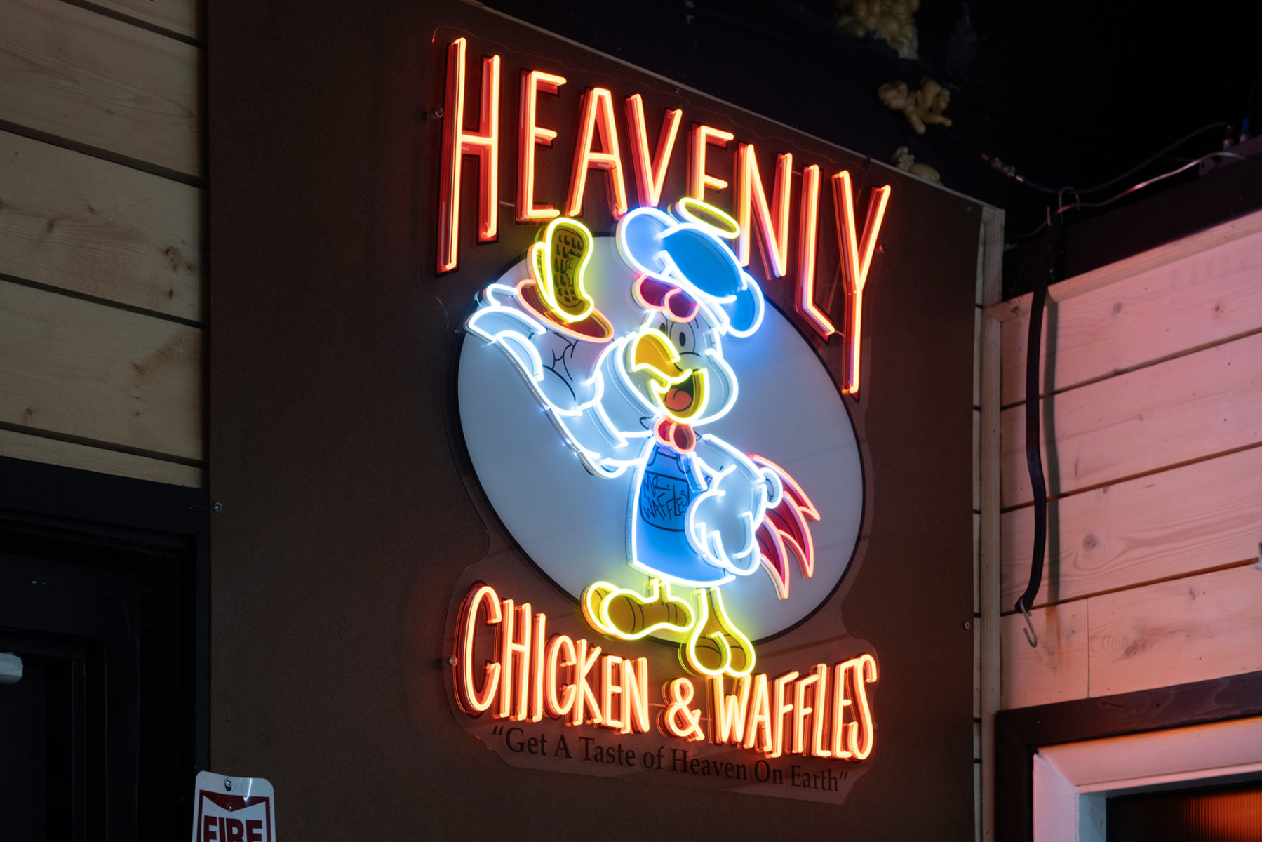 The Heavenly Chicken and Waffles neon sign glowing above the counter