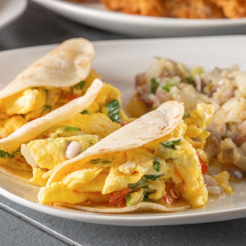 Breakfast tacos with scrambled eggs served with potatoes