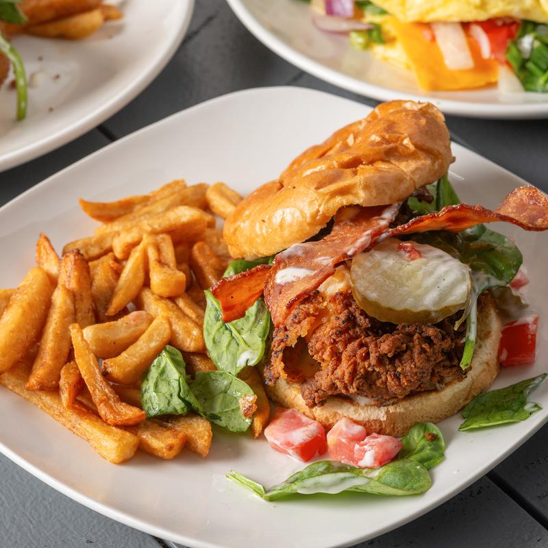Fried chicken and bacon sandwich served with crispy fries