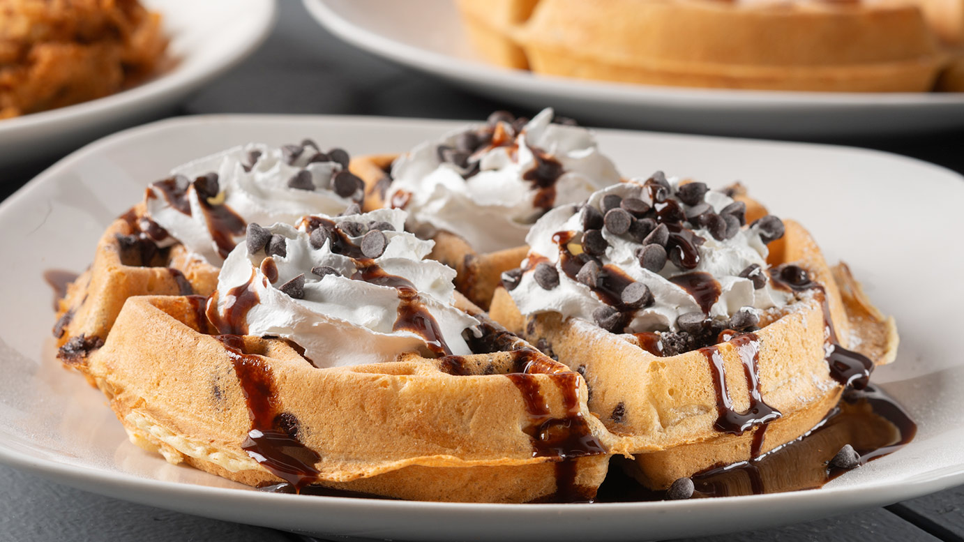 Chocolate chip waffle with whipped cream and chocolate drizzle