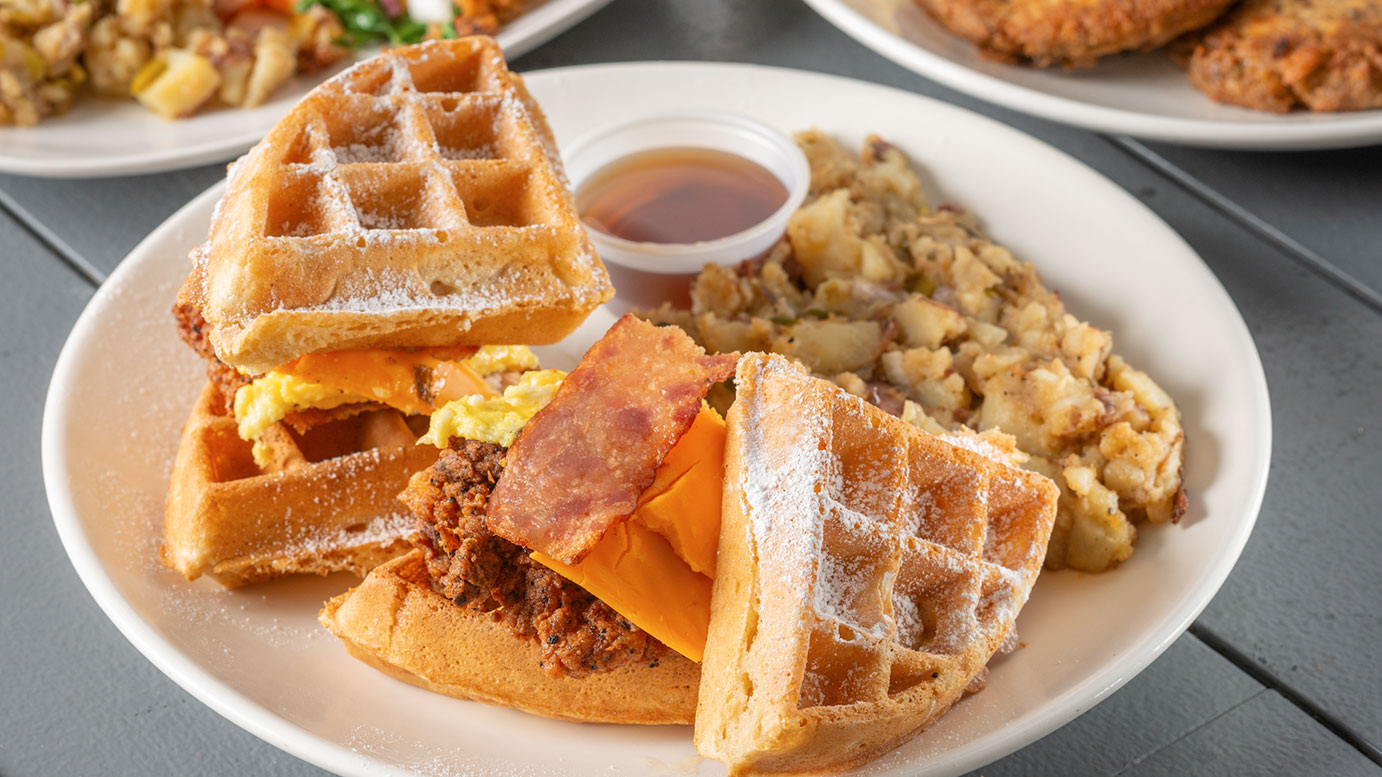 Waffle sandwich with chicken, egg, bacon and cheese with heavenly potatoes