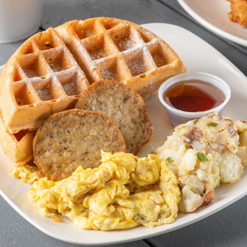 Waffle served with eggs, chicken sausage patties, potato salad and syrup