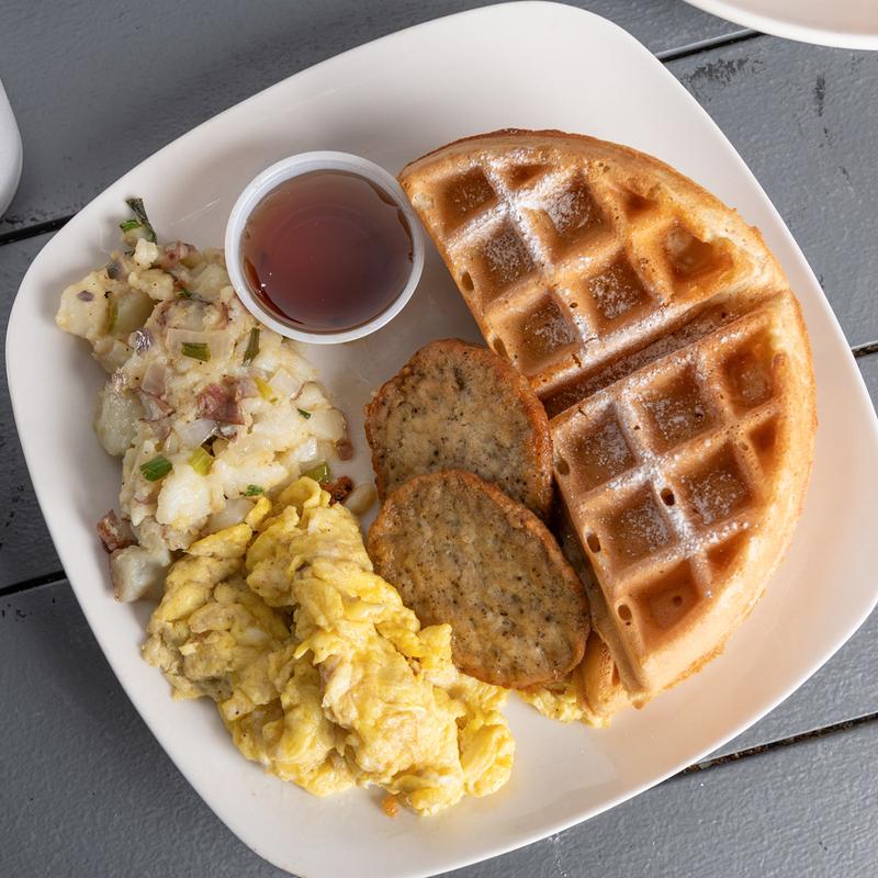 Belgian waffle with scrambled eggs, sausage patties, heavenly potatoes and syrup