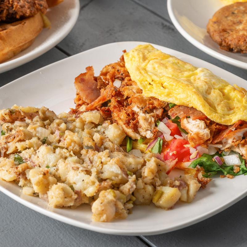 Breakfast plate with omelet, crispy potatoes and seasoned meat